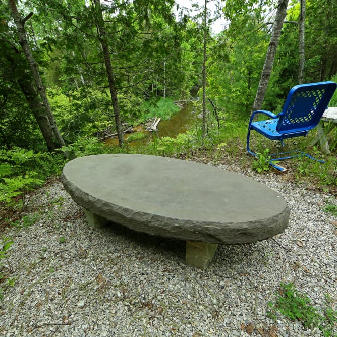 A stone bench in a winter setting.