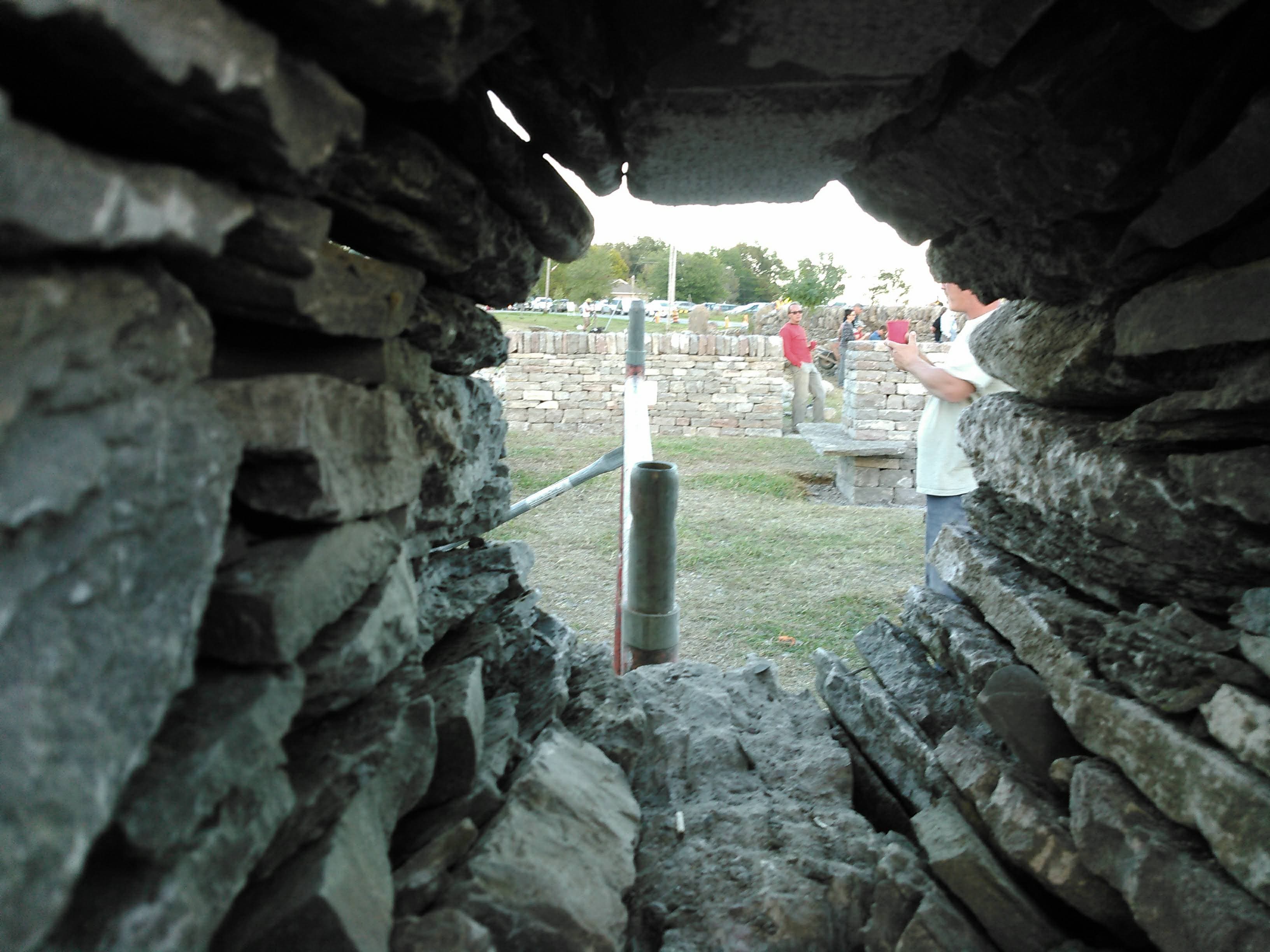 A dry stone test panel being built and read by a group of students.