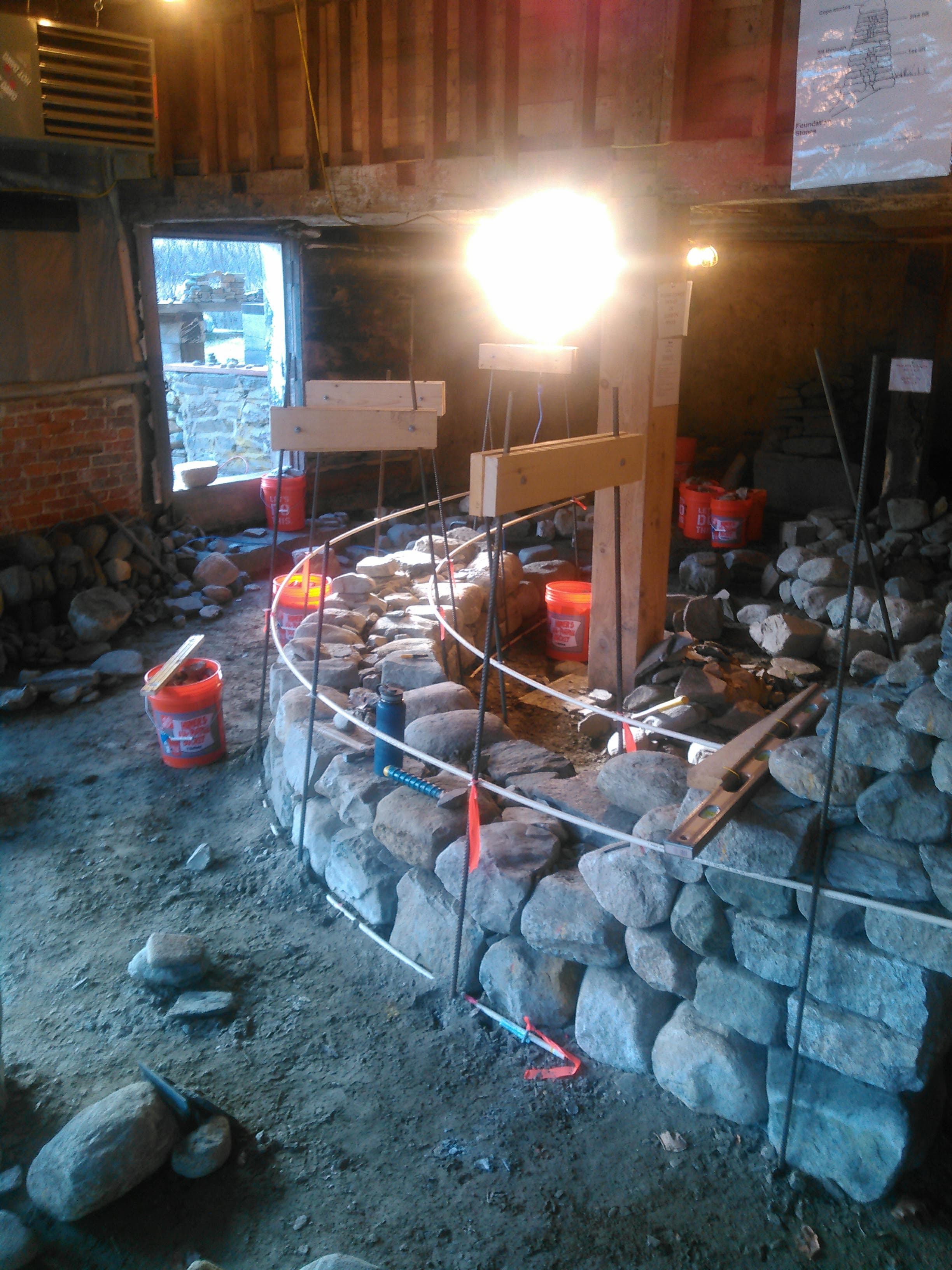 A round dry stone wall under construction during a class.
