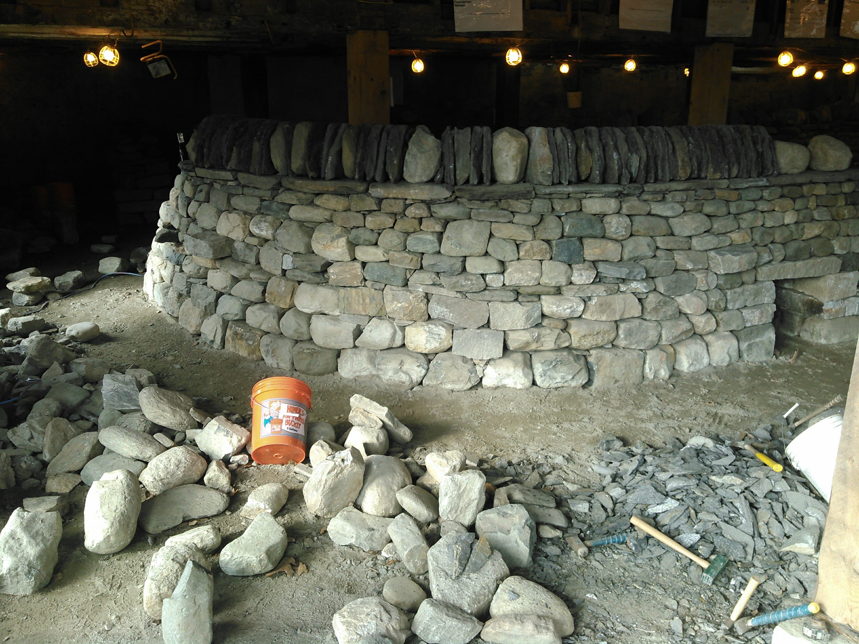 A finished round dry stone wall built indoors during a workshop.