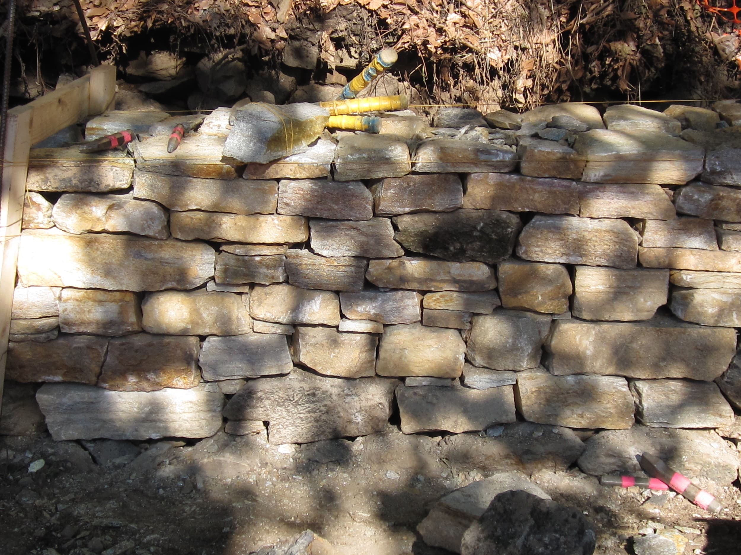Perimeter retaining wall under rebuild at Wyman Park Dell.