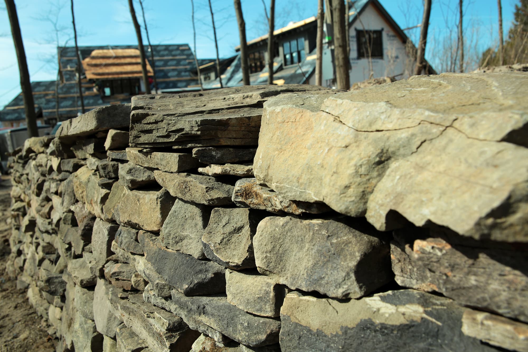 Close detail of rounded fieldstone in the wall face.