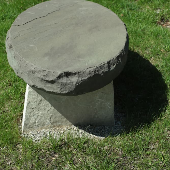 Elliptical stone bench in a landscaped setting.