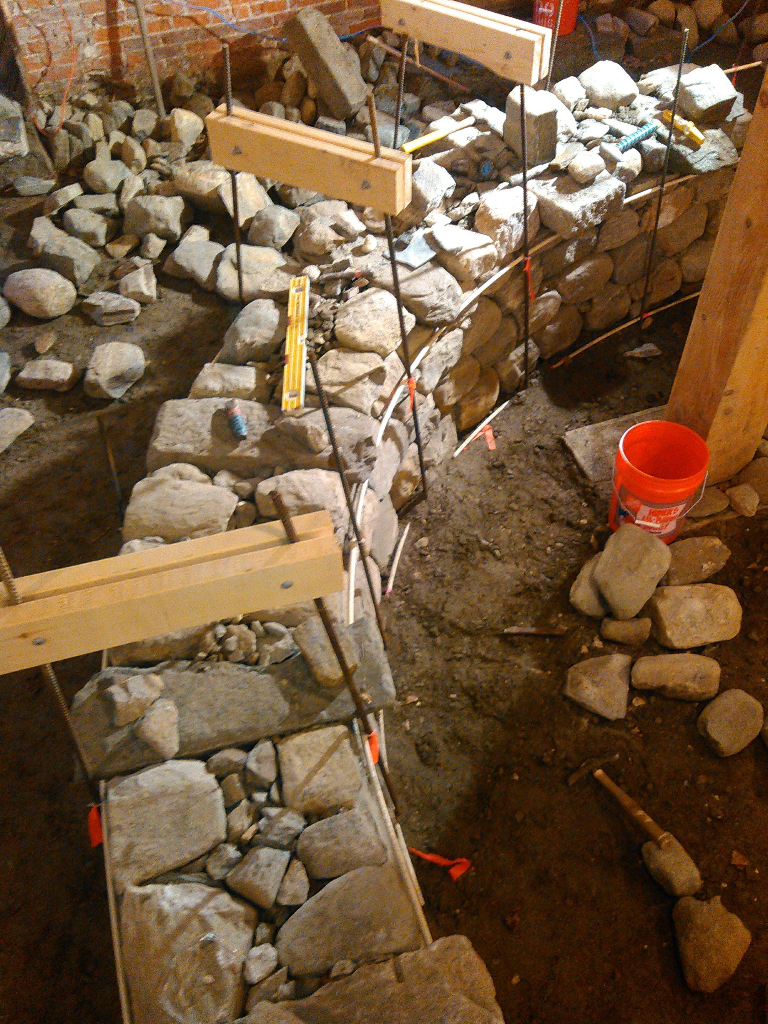 Dry stone wall under construction with packed stone and a working face.